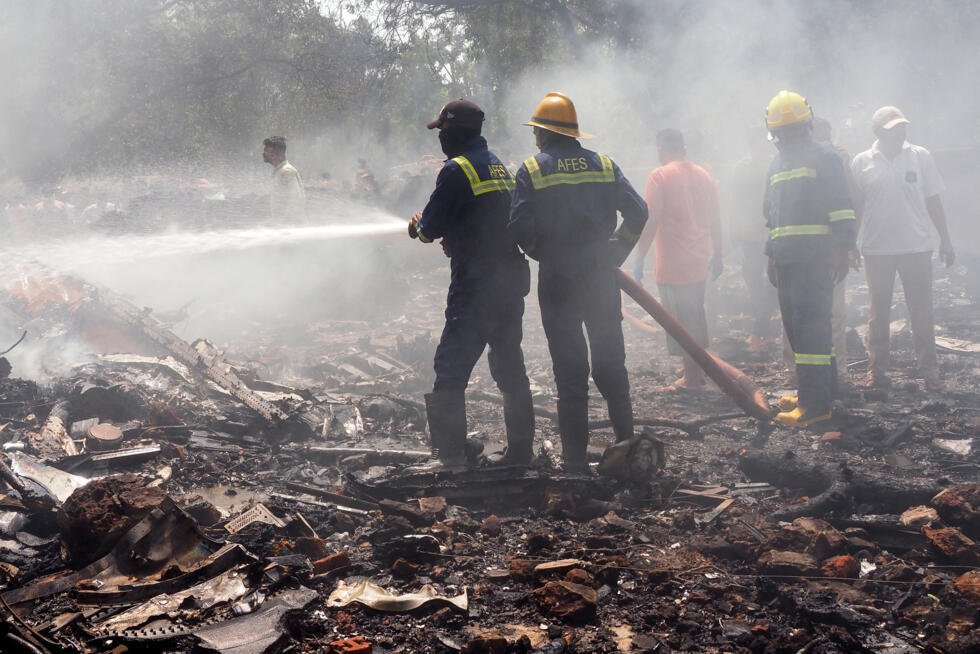 Firefighters work at the site where Air India flight 171 crashed in a residential area near the airport in Ahmedabad on June 12, 2025.