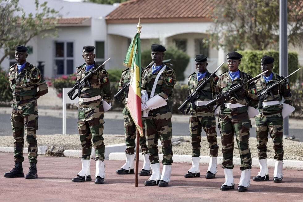 A Senegalese soldier holds a Senegal flag during a ceremony where France will return Camp Geille, its largest base in the country, and its airfield at Dakar airport, in Dakar on July 17, 2025.