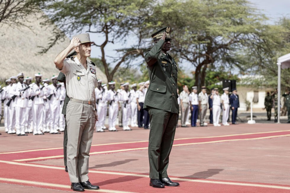 Senegal's Chief of General Staff, General Mbaye Cisse (R), and France's General Pascal Ianni, who commands France's troops in Africa, salute as the Senegalese flag is raised during a ceremony.