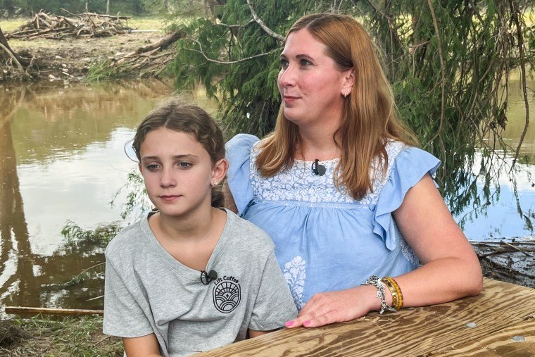 Lucky Kennedy, left, and Wynne Kennedy, sit at a wooden table outside