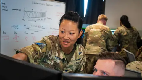 BBC/Matthew Goddard Colonel Phoenix Hauser points at a screen at her base